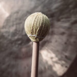 Closeup of mallet hitting a large gong